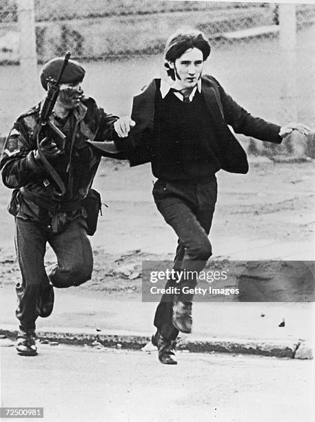 British paratrooper takes a captured youth from the crowd on "Bloody Sunday," when British paratroopers opened fire on a civil rights march, killing...