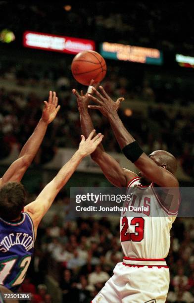 Michael Jordan of the Chicago Bulls shoots the ball as he is guarded by John Stockton of the Utah Jazz during game six of the NBA Final at the United...
