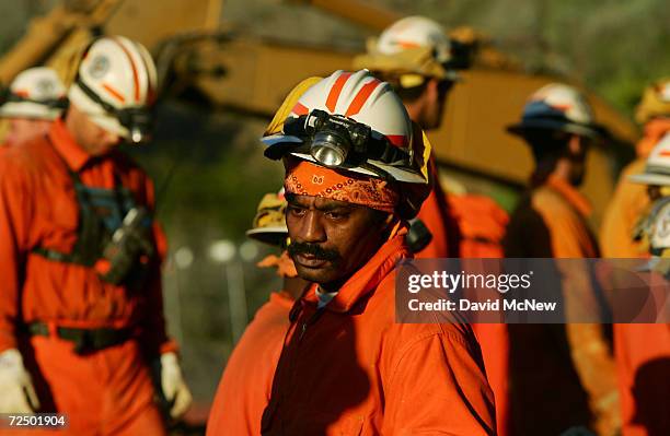 Member if the Acton, California, prisoner crew pauses while working on a bucket brigade in the debris of a mudslide as rescuers continue searching...