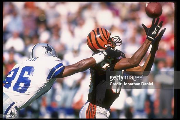 Wide receiver Darnay Scott of the Cincinnati Bengals goes for the ball as Dallas Cowboys defensive back Kevin Smith covers him during a game at...
