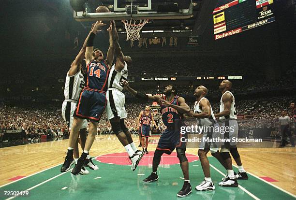 Chris Dudley of the New York Knicks gets hammered as he goes to the basket by Tim Duncan and David Robinson of the San Antonio Spurs during game two...