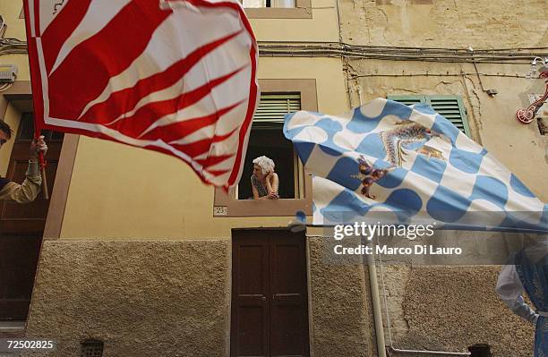 An elderly woman looks at two Standard bearers belonging to the Onda and the Giraffe on June 28, 2004 in Siena, Italy. The city?s 17 separate...