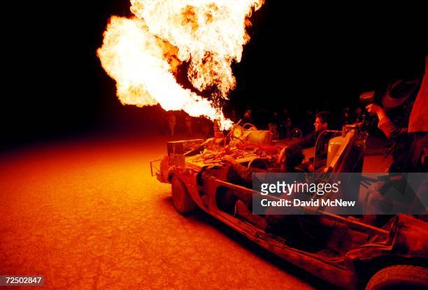 Flames shoot from an "art car" as it drives across the desert during the15th annual Burning Man festival September 2, 2000 in the Black Rock Desert...