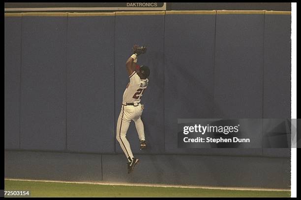 Andruw Jones of the Atlanta Braves catches a ball during Game Three of the World Series against the New York Yankees at Fulton County Stadium in...