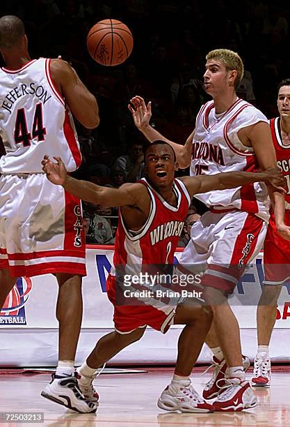 Guard Travon Davis of the Wisconsin Badgers tries to maintain control of the ball against forwards Richard Jefferson and Rick Anderson of the Arizona...