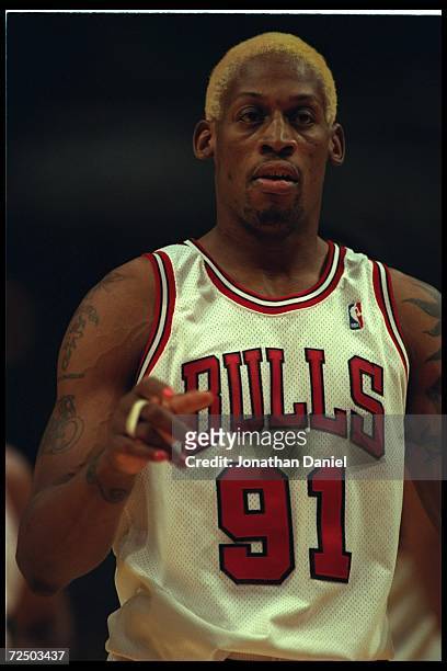Guard Dennis Rodman of the Chicago Bulls stands on the court at the United Center in Chicago, Illinois, during the game against the Seattle...