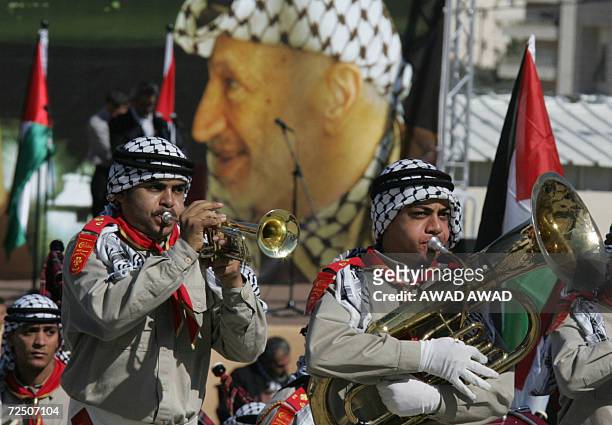 Palestinian musicians perform in front of a huge portrait of late Palestinian leader Yasser Arafat during cermeonies to commemorate the second...