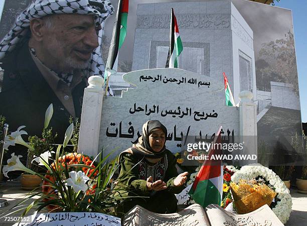 Palestinian woman mourns at the grave of late Palestinian leader Yasser Arafat during cermeonies to commemorate the second anniversary of the...