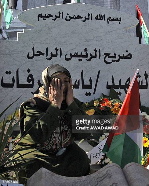 Palestinian woman prays at late leader Yasser Arafat's gravesite during ceremonies to commemorate the second anniversary of his death, 11 November...