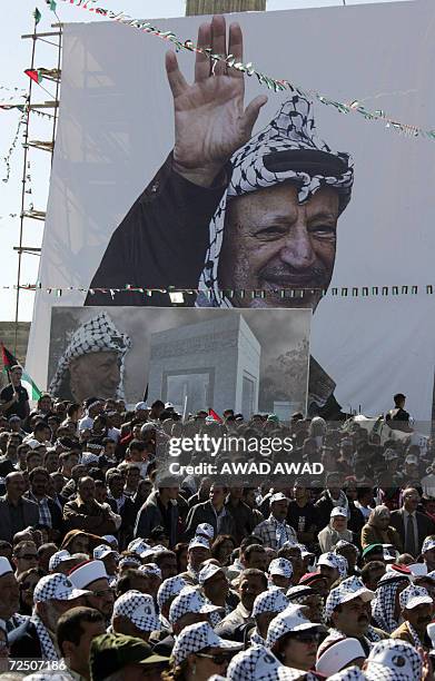 Huge portrait of late Palestinian leader Yasser Arafat stands above the crowd during ceremonies to commemorate the second anniversary of his death,...