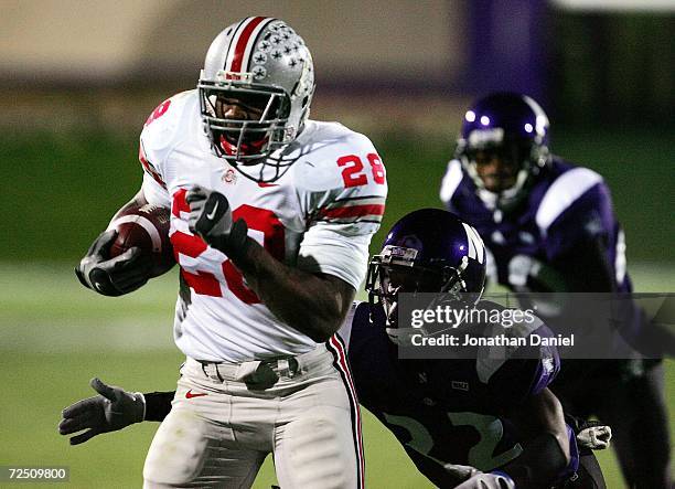 Chris Wells of the Ohio State Buckeyes runs past Deante Battle of the Northwestern Wildcats on November 11, 2006 at Ryan Field in Evanston, Illinois....