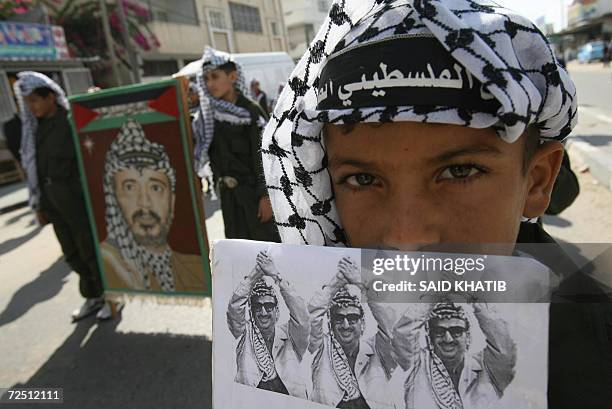 Palestinian boys dress up as the late leader Yasser Arafat as they hold his image during a march through the southern Gaza Strip town of Rafah, 12...