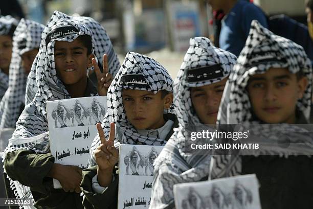 Palestinian boys dressed up as the late leader Yasser Arafat march through the streets of the southern Gaza Strip town of Rafah, 12 November 2006,...