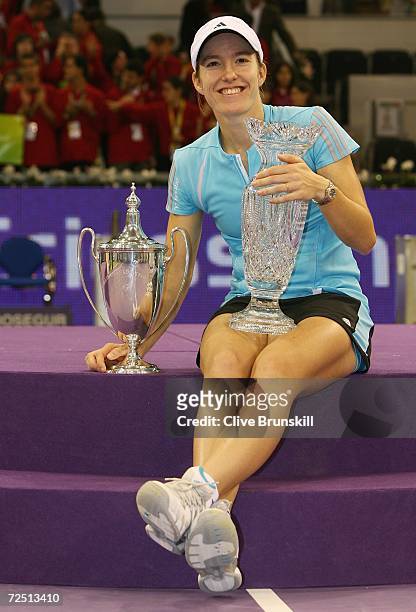Justine Henin-Hardenne of Belgium poses with the Championship trophy and the Billie Jean King trophy after defeating Amelie Mauresmo of France during...