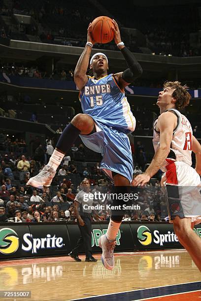 Carmelo Anthony of the Denver Nuggets shoots over Matt Carroll of the Charlotte Bobcats on November 12, 2006 at the Charlotte Bobcats Arena in...