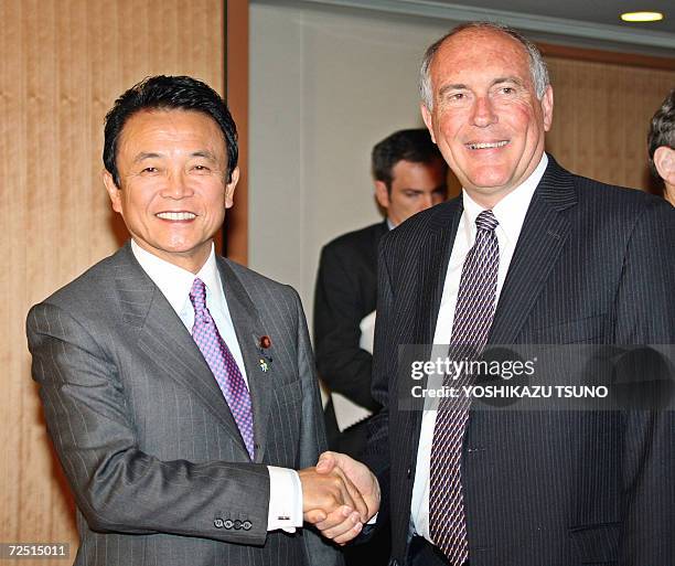 Visiting Australian Trade Minister Warren Truss shakes hands with Japanese Foreign Minister Taro Aso prior to their talks at Aso's office in Tokyo,...