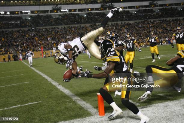 Running back Reggie Bush of the New Orleans Saints scores on a 15-yard touchdown run against defensive backs Tyrone Carter and Bryant McFadden of the...