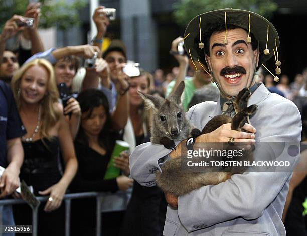 British comedian Sacha Baron Cohen dressed as his alter ego 'Borat' carries a wallaby and wears a tradition Australian bush hat to the Australian...