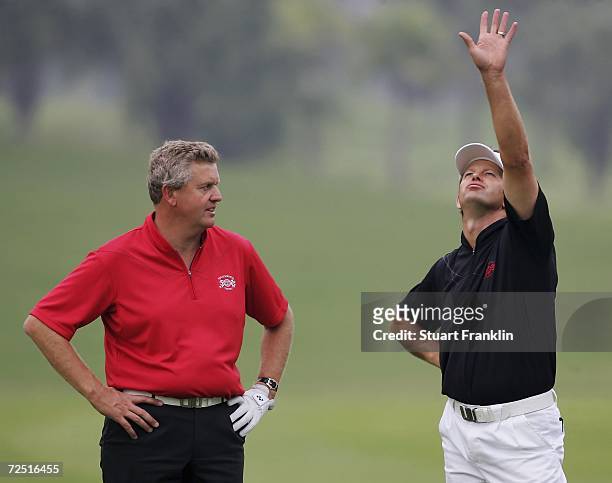 Retief Goosen, Captain of the International team gestures to Colin Montgomerie of Scotland, Captain of The Ryder Cup Nations team during the first...