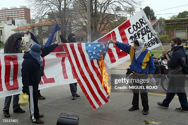 Manifestantes queman frente a la residencia presidencial en Montevideo una bandera de Estados Unidos en protesta contra un posible Tratado de Libre...