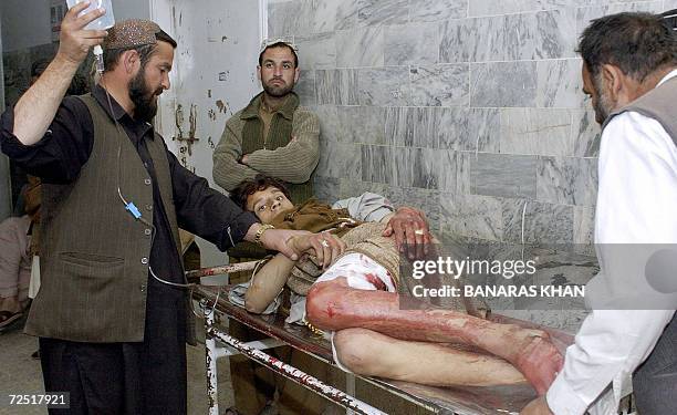 Pakistani paramedics carry an injured victim of a bomb blast at a hospital in Quetta, 13 November 2006. A bomb attached to a bicycle killed a child...