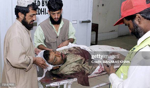 Pakistani personnel of the private humanitarian organisation Edhi Welfare Trust checks the identity document of a dead man at a hospital in Quetta,...