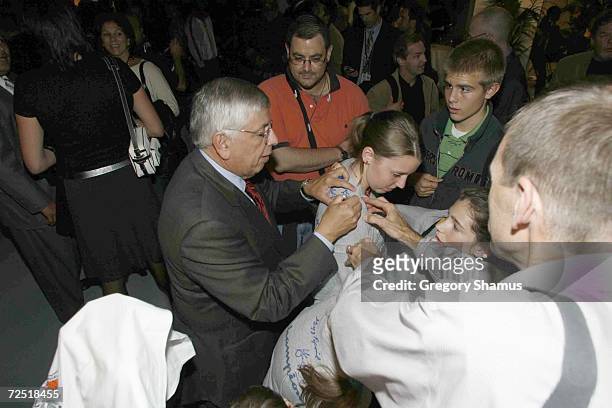 Commissioner David Stern signs a young fans shirt before a game between the San Antonio Spurs and Maccabi Elite on October 8,2006 in Paris, France....