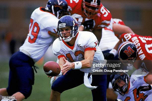 Mike Groh of the Virginia Cavaliers hands off the ball during a game against the Maryland Terrapins at the Byrd Stadium in College Park, Maryland....
