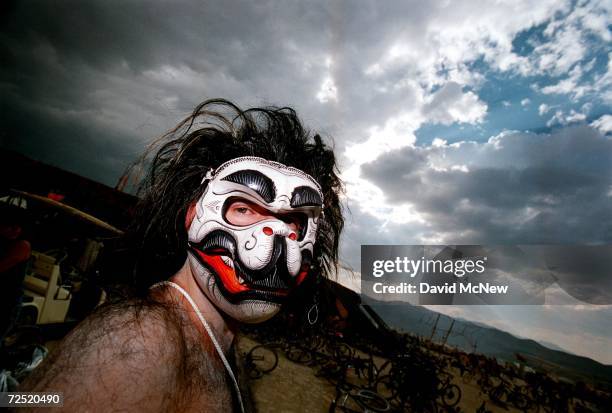 Man wearing an animal mask glances at the camera during the15th annual Burning Man festival September 2, 2000 in the Black Rock Desert near Gerlach,...