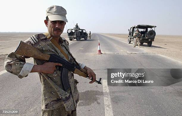 An Iraqi National Guard soldier stands at a check point on the Tampa road from Basrah to Baghdad near the Italian base Camp Mittica on October 11,...