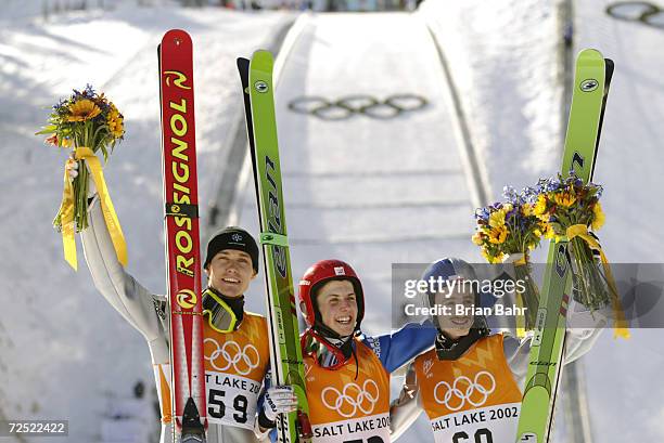 Silver medalist Sven Hannawald of Germany, gold medalist Simon Ammann of Switzerland and Adam Malysz of Poland celebrate during the flower ceremony...