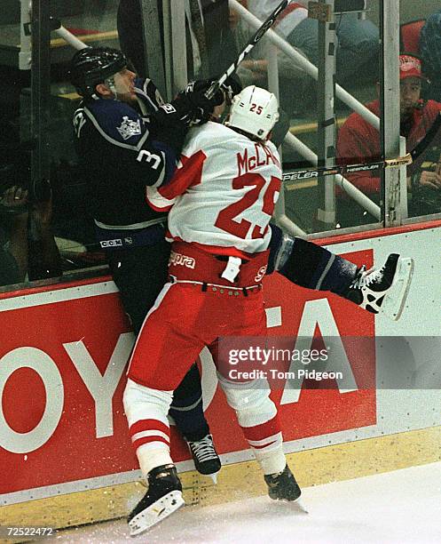 Garry Galley of the Los Angeles Kings is checked into the boards by Darren McCarty of the Detroit Red Wings during their opening round Western...