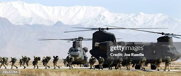 Soldiers from the U.S. Armys 10th Mountain and 101st Airborne Division disembark from their chinook helicopter March 12, 2002 after returning to...