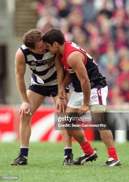 Brenton Sanderson for Geelong and Jeff Farner for Melbourne exchange words during the round 18 AFL match played between the Melbourne Demons and the...