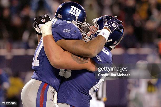 Center Shaun O'Hara of the New York Giants embraces teammate running back Tiki Barber after his game-winning touchdown against the Dallas Cowboys on...