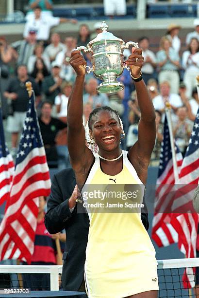 Serena Williams smiles and poses with her trophy after winning the US Open at the USTA National Tennis Courts in Flushing Meadows, New York.