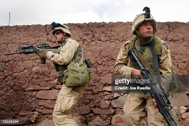 United States Army 10th Mountain soldiers keep an eye out for enemies as they take over dwellings March 8, 2002 near the villages of Sherkhankheyl,...