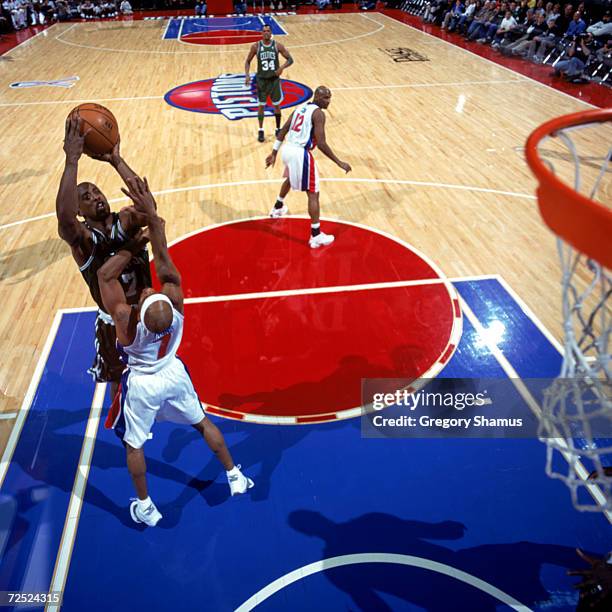 Point guard Kenny Anderson of the Boston Celtics shoots over point guard Chucky Atkins of the Detroit Pistons during the NBA game at the Palace of...