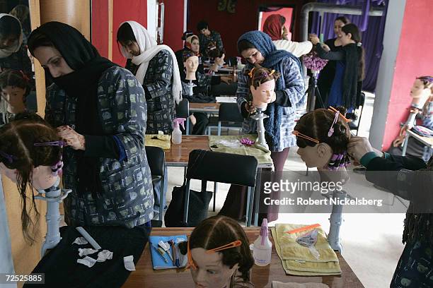 Afghan women practice on mannequin heads at Debbie Rodriguez's Oasis Beauty School February 13, 2005 in Kabul, Afghanistan. Rodriguez operates the...