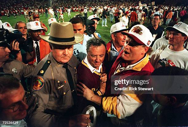 FLORIDA STATE SEMINOLES HEAD COACH COACH BOBBY BOWDEN IS ESCORTED OFF THE FIELD AFTER HIS TEAM DEFEATED NEBRASKA, 18-16 IN THE 1994 ORANGE BOWL IN...