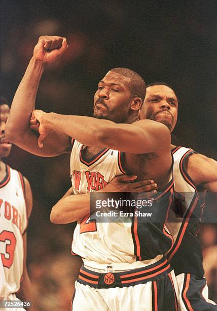 Larry Johnson of the New York Knicks is hugged from behind by teammate Latrell Sprewell after Johnson hit a three-point basket to give the Knicks a...