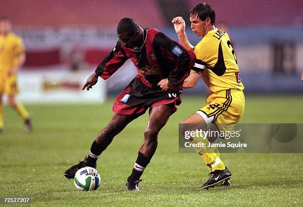 Adolfo Valencia of the New Jersey/New York MetroStars dribbles the ball while being guarded by Mike Lapper during the game against the Columbus Crew...