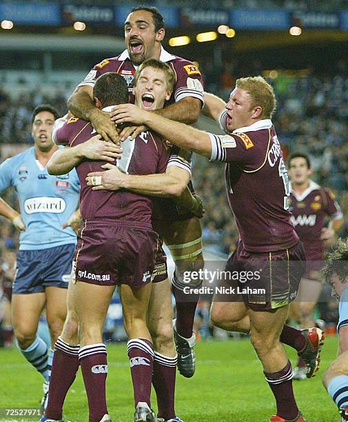 Scott Prince of the Maroons is congratulated by Brent Tate, Tonie Carroll and Michael Crocker during game one of the NRL State of Origin Series...