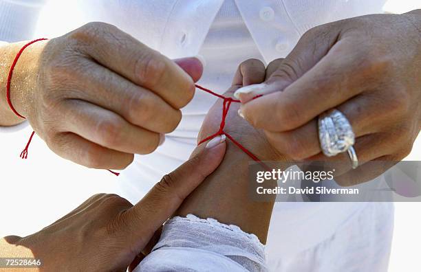 Jewish women of the Saadoun family from Paris, France, wear their Kabbalah Red String Bracelets while praying at the Western Wall, Judaism's holiest...