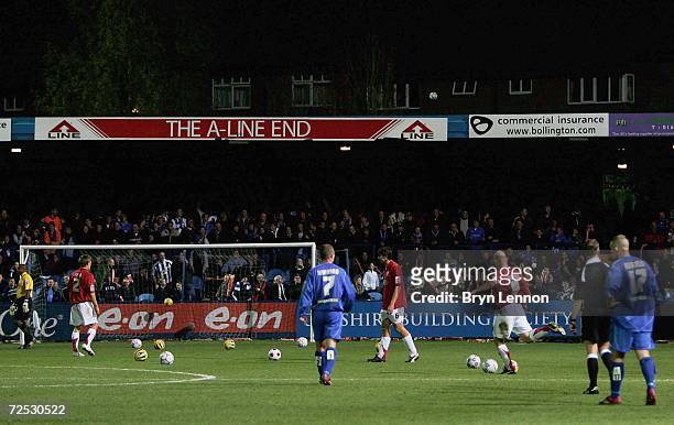 The players look on as footballs are suddenly fired on to the pitch mid-game during the FA Cup First Round match between Macclesfield Town and...
