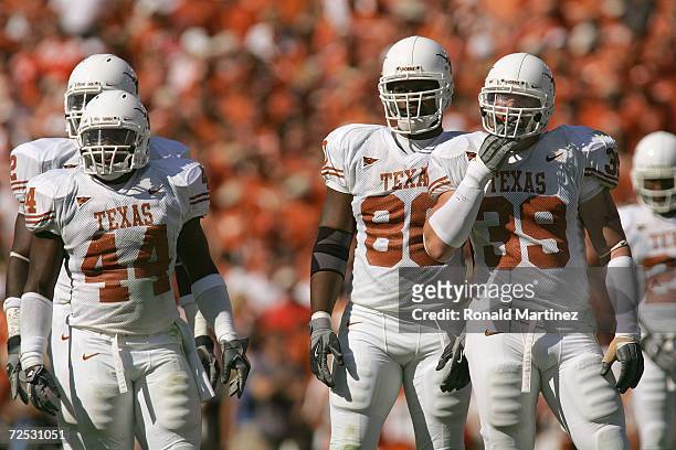 Linbacker Rashad Bobino, defensive ends Brian Robison and Tim Crowder of the Texas Longhorns stand on the field during the Red River Shootout against...