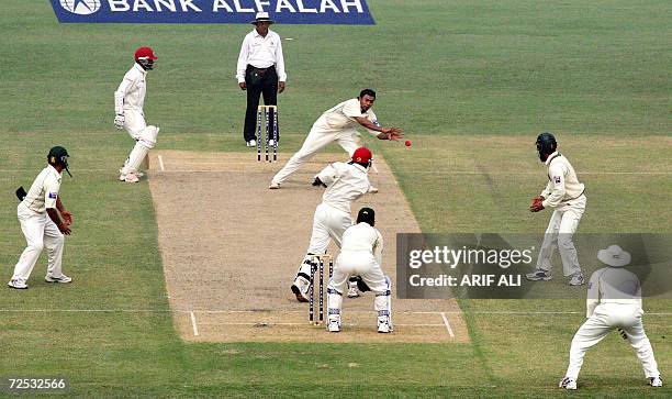 Pakistani cricketer Danish Kaneria tries to take a return catch of his own bowling as West Indies batsman Dwayne Bravo plays the ball in the air...