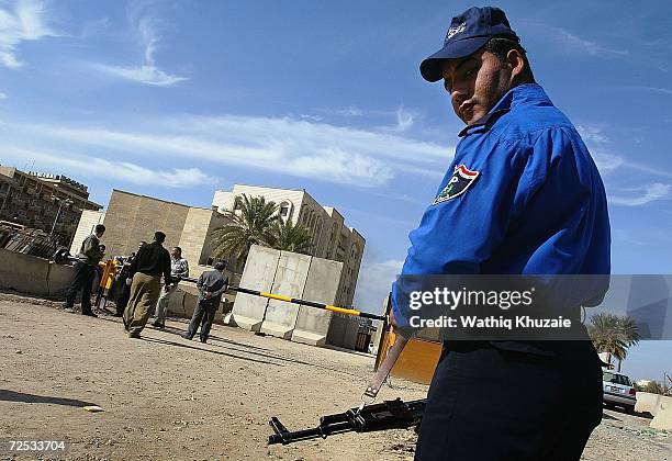 An Iraqi policeman stands guard in front of an Iraqi Higher Education building where some 100 government employees and visitors were kidnapped on...