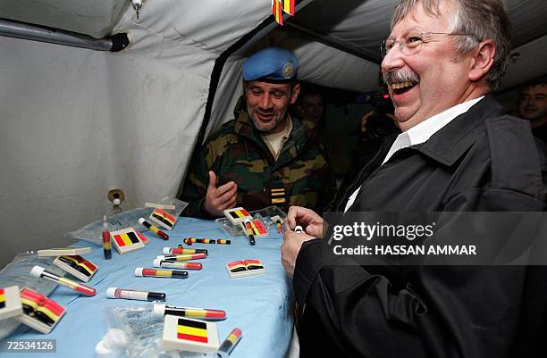 Belgian Defense Minister Andre Flahaut looks at toy medical equipments, bearing the colors of the Belgian flag, inside a tent of his troops in the...