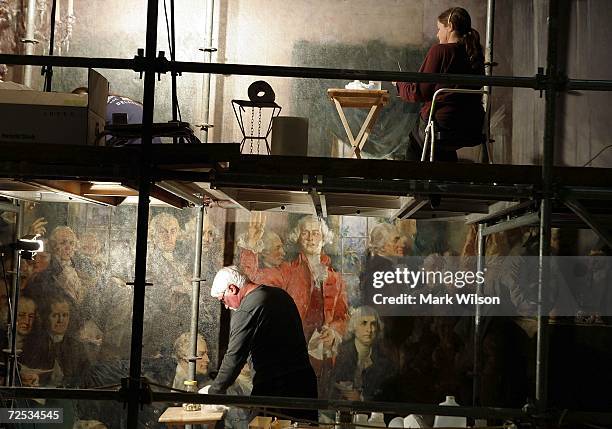 Art restorers on scaffolding work on a wall painting of the founding fathers in a stairwell of the U.S. Capitol November 14, 2006 in Washington DC....